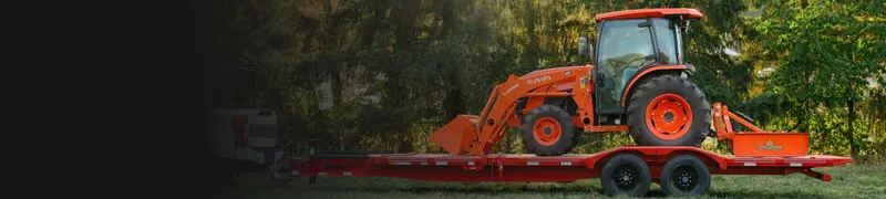 Orange tractor loaded on a red Diamond C equipment trailer